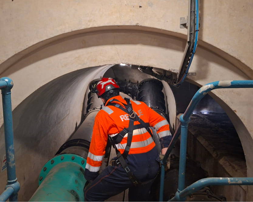A man in high-vis overalls in a Confined Space carrying out a rescue operation, working for AGO Fire & Rescue