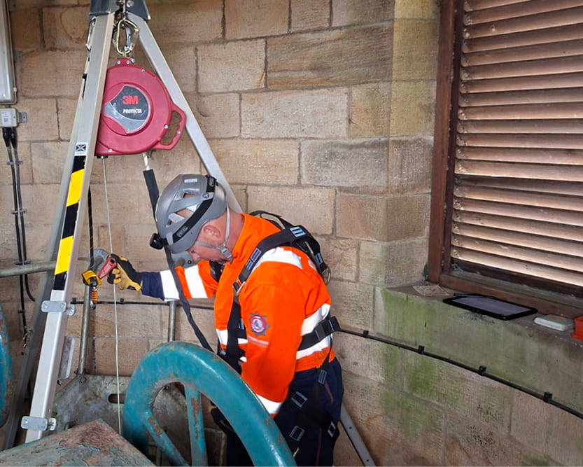 A technical rescue operative wearing high-visibility overalls assisting with a Confined Space Rescue operation